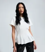 Blusa de algodón color blanco con cuello redondo y mangas cortas. Presenta un diseño peplum con pliegues en la cintura que realzan la silueta.