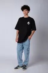 Remera negra de corte oversize confeccionada en algodón pesado, con estampa pequeña de Mickey Mouse en el pecho y diseño gráfico en la espalda.