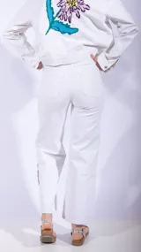 Pantalón de jean blanco con bordado de flores en el ruedo.