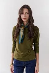 Remera de manga larga color verde militar, con cuello redondo y costuras decorativas en blanco.