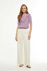 Pantalón palazzo color arena, de tiro alto y corte amplio.