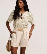 Short recto de cintura alta color crudo, confeccionado en viscolino, con trabillas en la cintura, pliegues y cierre tradicional. Incluye cinturón de rafia artificial con hebillas de argollas.