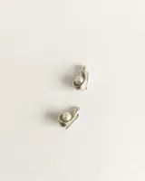 Aros en forma de gota de plata con perla de río engarzada en el centro.
