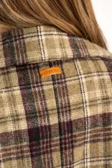 Tapado de corte recto y largo medio, confeccionado en tela de poliéster con estampado de cuadros en tonos verdes, marrones y violetas. Presenta solapas clásicas, cierre frontal y diseño estructurado.