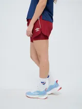 Short deportivo azul marino de mujer con calza interior celeste. Cuenta con cintura elástica ajustable con cordón y detalles de la marca Umbro y del Club Nacional de Football.