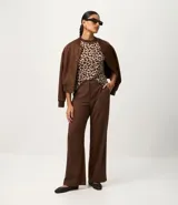 Remera de punto con estampado animal print de leopardo en tonos marrones y beige, de corte regular, cuello alto redondo contrastante y manga corta.