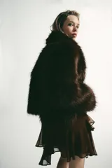 Abrigo corto de Zara confeccionado en pelo sintético de textura suave, color marrón oscuro. Presenta cuello solapa, manga larga y cierre frontal con ganchos metálicos ocultos.