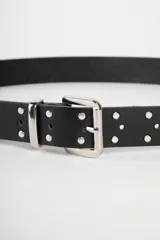 Cinturón blanco de cuero sintético con hebilla metálica plateada de doble trabilla y tachas metálicas plateadas.