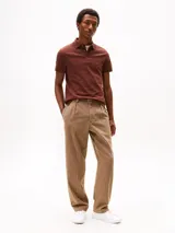 Chomba color ladrillo de Tommy Hilfiger, corte slim, con cuello clásico, tapeta de dos botones y logo bordado en el pecho.