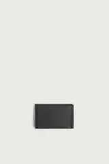 Tarjetero plegable de piel vacuna color negro, con diseño texturizado, cuatro ranuras para tarjetas y monedero con cierre de broche a presión.