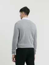 Sweater de punto con escote en V y manga larga, con puños y ruedo acanalados.