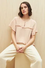 Blusa negra con textura, canesú con encaje, volados, corte fluido y mangas cortas amplias.