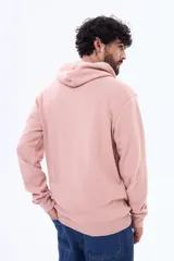 Buzo tipo canguro con capucha y cordones ajustables, confeccionado en felpa color rosado. Presenta un estampado frontal con diseño de montañas y el texto 'COLORADO Rocky Mountain'. Cuenta con bolsillo frontal tipo canguro y puños acanalados.