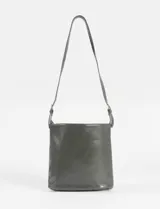 Cartera bandolera de cuero vegano color bordó, con diseño estructurado y detalle de cuatro hebillas metálicas decorativas en el lateral. Cuenta con correa larga ajustable y cierre principal.