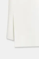 Pantalón de tiro medio de ZARA Woman Collection confeccionado en hilatura de viscosa. Cuenta con cintura con trabillas, bolsillos laterales, raya planchada y pierna recta con bajo asimétrico y aberturas. Cierre frontal con cremallera, botón y ganchos metálicos.