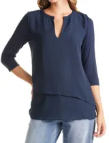 Blusa de diseño asimétrico con frente superpuesto en gasa y mangas tres cuartos. Presenta escote en V con pequeña abertura y espalda en tejido modal.