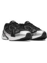 Championes deportivos Under Armour modelo Sola, con diseño futurista en color negro, detalles plateados y suela blanca. Presentan parte superior ligera con superposiciones, refuerzo de TPU en el talón y entresuela de EVA acolchada.