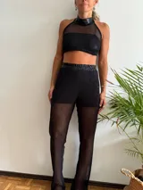 Pantalón de red color negro, con diseño de tejido abierto y corte recto, ideal para usar sobre trajes de baño.