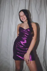 Vestido corto de color verde esmeralda, con escote en pico y breteles finos. Presenta aberturas en los laterales de la cintura y espalda descubierta.