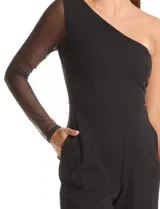 Enterito negro de crepe premium con caída pesada y fluida. Presenta un escote asimétrico, una única manga larga de mesh transparente y pierna de corte recto. Incluye bolsillos laterales invisibles y cierre invisible en la espalda.
