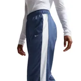Pantalón deportivo Nike de corte recto y ajuste holgado, confeccionado en tejido técnico de acabado mate. Presenta cintura elástica con cordón ajustable y el logo de la marca bordado en pequeño en la parte superior de la pierna.