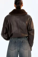 Jean de cinco bolsillos en denim de algodón rígido, color azul oscuro con efecto desgastado. Modelo de cintura clásica con cierre y botón, corte holgado y piernas anchas tipo barrel con costuras laterales marcadas.