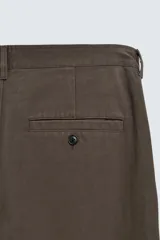 Pantalón chino de corte recto confeccionado en algodón. Presenta bolsillos frontales, un pequeño bolsillo cerillero y bolsillos traseros de vivo con botón. Cierre frontal con cremallera y botón.