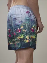 Short de baño con estampado botánico en tonos naranja y coral, con cintura elástica ajustable mediante cordón y malla interior para mayor soporte.