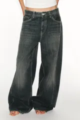 Jeans de tiro medio y corte baggy oversize con diseño de costuras marcadas en las piernas, trabillas para cinturón y cinco bolsillos tradicionales. Cierre frontal con cremallera y botón metálico.