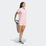Remera de running Adidas de manga corta, color rosa pálido, con cuello redondo y ajuste regular. Presenta las tres franjas reflectantes en las mangas y el logo de Adidas en el pecho.