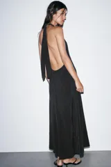 Vestido midi de tejido fluido color negro, con cuello halter anudado en la nuca y escote en pico.