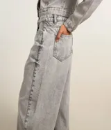 Pantalón de jean estilo baggy con corte holgado y recto, de tiro alto, con trabillas en la cintura, cierre tradicional y bolsillos laterales y traseros.