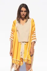 Ruana tejida a rayas horizontales en tonos amarillo, naranja y blanco, con flecos en el borde inferior.