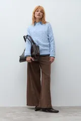 Sweater de punto con textura de ochos, cuello redondo y mangas largas, en color celeste.