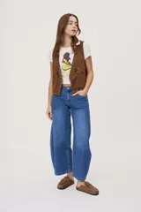 Jean de tiro medio y corte barrel con pierna amplia y ligeramente curva, estilo de cinco bolsillos en denim negro lavado.