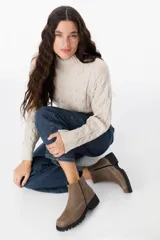 Bota corta tipo chunky color visón, confeccionada en cuero, con suela track dentada negra y costuras decorativas a la vista.