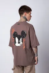 Remera negra de algodón de corte oversize, con mangas cortas y cuello redondo. Estampado pequeño en el frente y diseño grande en la espalda con Mickey Mouse y caracteres orientales en tonos rojizos.