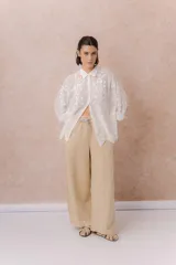 Pantalón de denim liviano color beige, de calce amplio y relajado con pierna recta. Cuenta con cintura elastizada, cordón regulable, bolsillos laterales y costuras delanteras verticales que estilizan la silueta.