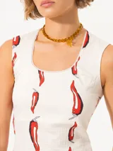 Musculosa blanca con estampado de pimientos rojos, escote redondo con detalle de puntilla y calce al cuerpo.