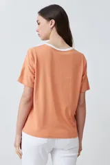 Remera de manga corta con diseño color block, combinando paneles en color blanco, naranja y verde agua.