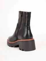 Bota de cuero color marrón con suela track y taco cuadrado acanalado.