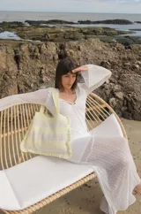 Bolso tipo tote tejido a crochet con hilo de algodón color marrón y crudo, con diseño a rayas horizontales y volados en los bordes.