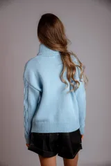 Suéter tejido de punto trenzado color salmón, con cuello alto y mangas largas. Corte ajustado al cuerpo.