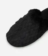 Pantufla cerrada de mujer con textura de peluche suave en color negro, diseñada para brindar comodidad en el hogar.