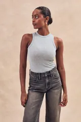 Musculosa de tejido acanalado con acabado brillante, de corte ajustado al cuerpo y cuello redondo alto.