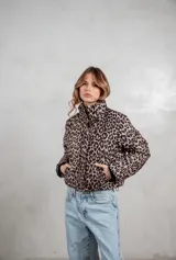 Campera puffer corta con estampado animal print, cuello alto y cierre frontal. Cuenta con bolsillos laterales y diseño acolchado.