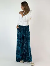 Pantalón palazzo de terciopelo turquesa con estampado floral.