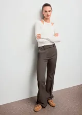 Camiseta de canalé color blanco, de manga larga y diseño entallado con cuello halter y detalles de aberturas.