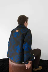 Cardigan de paño de lana con diseño de inspiración navajo en colores negro y azul. Presenta cuello smoking, cierre frontal con botones de guampa, bolsillos delanteros y puños con botón.