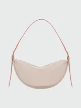 Bolso tipo crossbody de diseño semicircular, color gris claro, con correa ajustable y cierre superior.